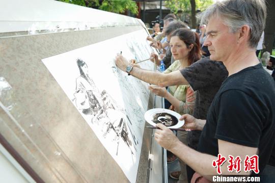 28日，来自法国、芬兰等7个国家的10位漫画家“手绘”北京，体味京城文化。　熊然　摄