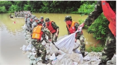 昨日上午，軍民們搬運(yùn)沙袋進(jìn)一步控制險(xiǎn)情       記者彭年 攝