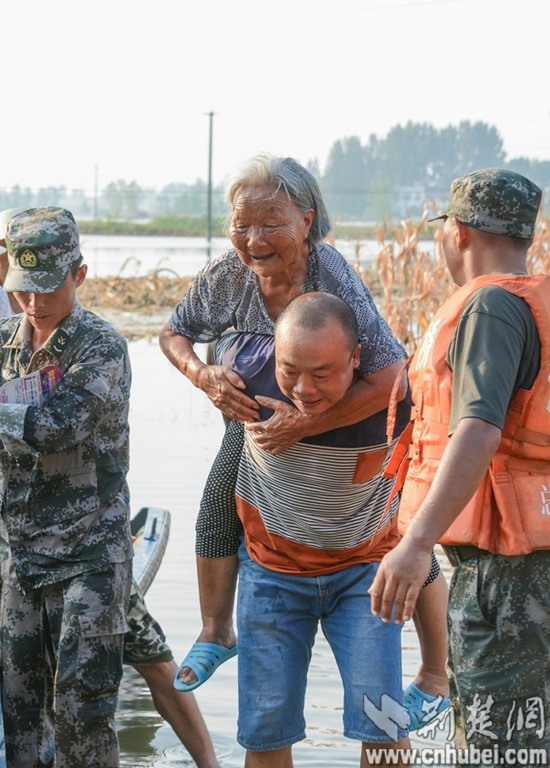 2016年7月27日，志愿者馬志威協(xié)助湖北預(yù)備役舟橋團(tuán)官兵轉(zhuǎn)移85歲的老人。（記者  張先國(guó)  陳勇  趙融 攝）DSC_7124_tn.jpg