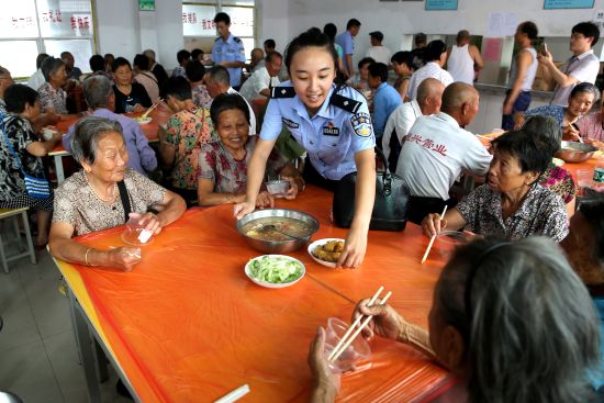 洪湖市公安局濱湖派出所民警葉紫在濱湖辦事處安置點(diǎn)照顧群眾生活 周圓 攝