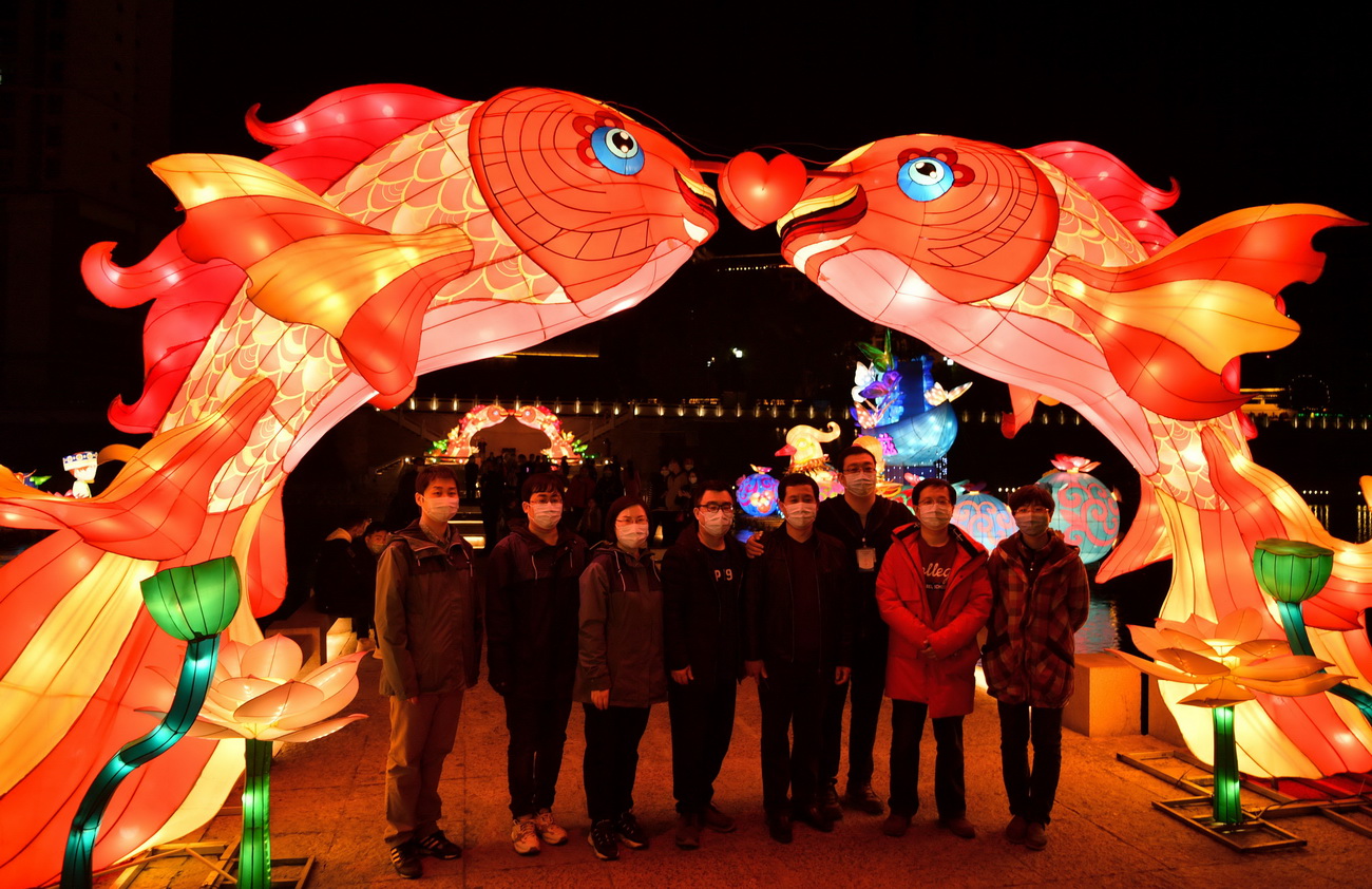 3月20日晚，天津市对口支援湖北恩施医疗队的队员们在宣恩县城贡水河畔的彩灯前合影留念。
