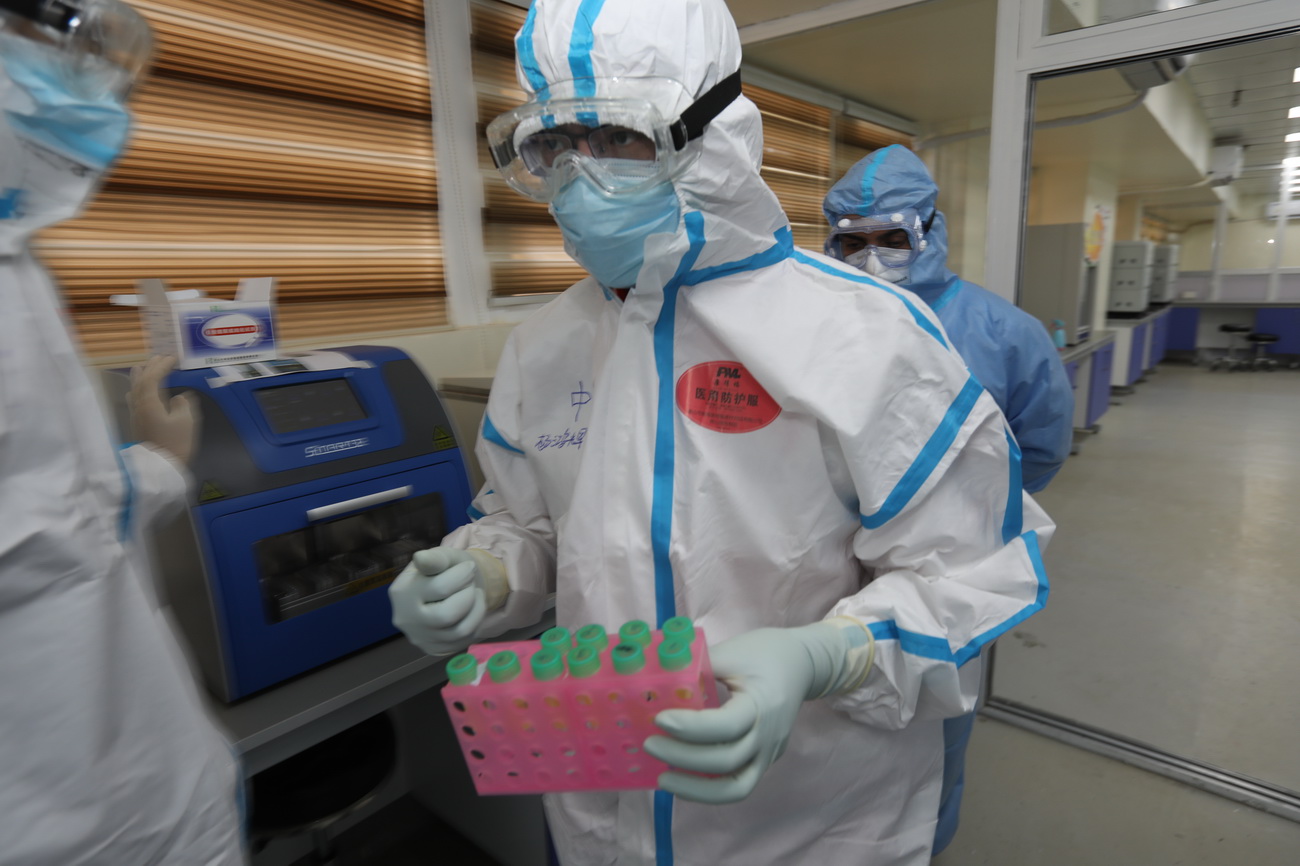 3月26日，在伊拉克巴格达，专家组成员、中山大学达安基因股份有限公司技术总监杨鸿辉（中）在中国援建伊拉克的核酸检测实验室工作。