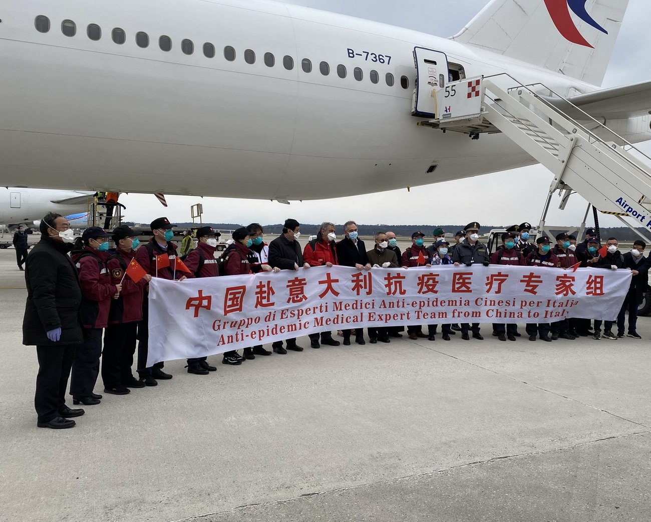 3月25日，在意大利米兰马尔奔萨机场，中国第三批赴意大利抗疫医疗专家组成员与意方人员合影。