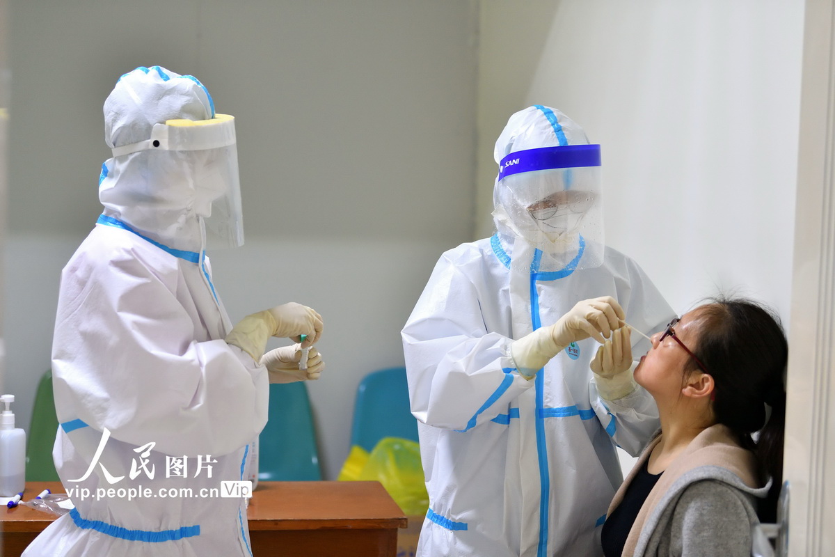 4月20日，在湖北省襄阳市保康县人民医院检测点，医务人员在给保康一中教师采集咽拭子。