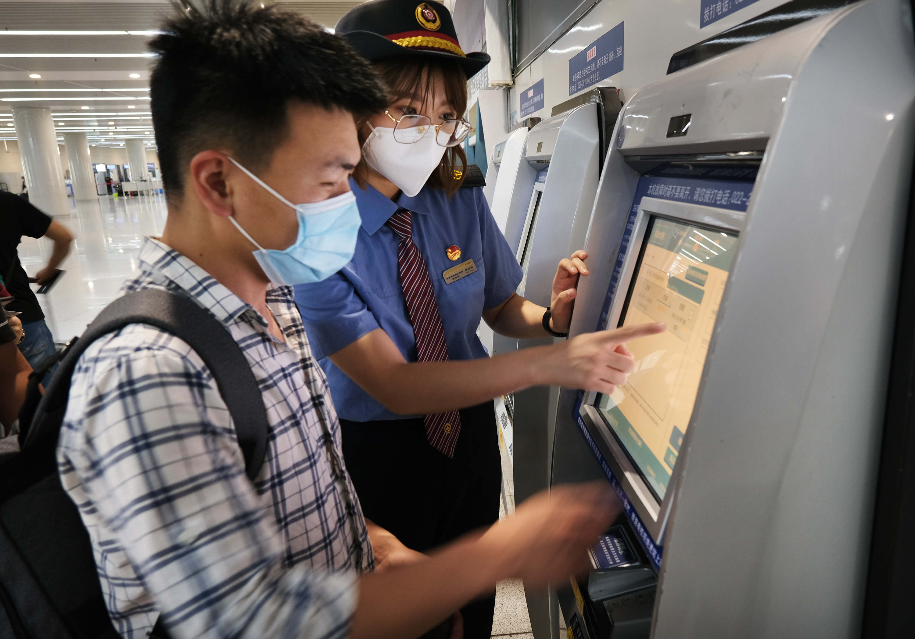 6月18日，天津站客运人员帮助旅客购买电子客票。 杨宝森/摄