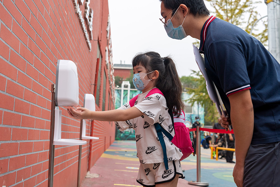 29日早上8时许，人民网记者在对外经济贸易大学附属小学门口看到，在老师的引导下，一年级新生们依次用消毒洗手液清洁双手，进入校园。