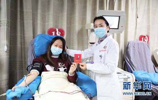 江汉大学学生朱瑞雯在21岁生日这天献血补过成人礼，为她采血的正是她的妈妈——武汉血液中心成分献血科护士谢晋。新华网发 汪昊摄