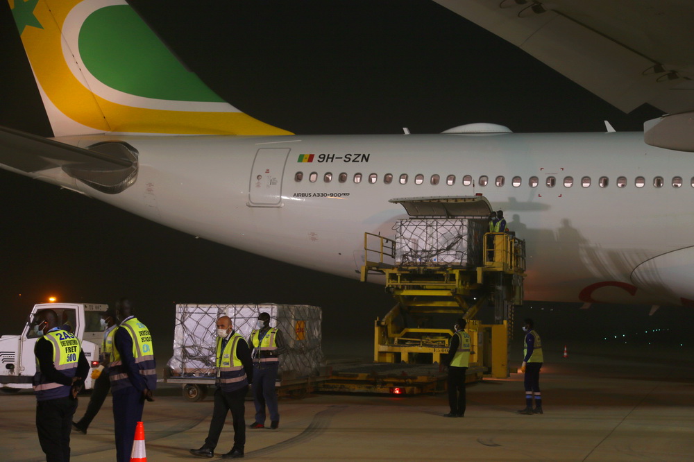 2月17日，塞内加尔达喀尔布莱兹·迪亚涅国际机场的工作人员在卸载从中国进口的第一批新冠疫苗。