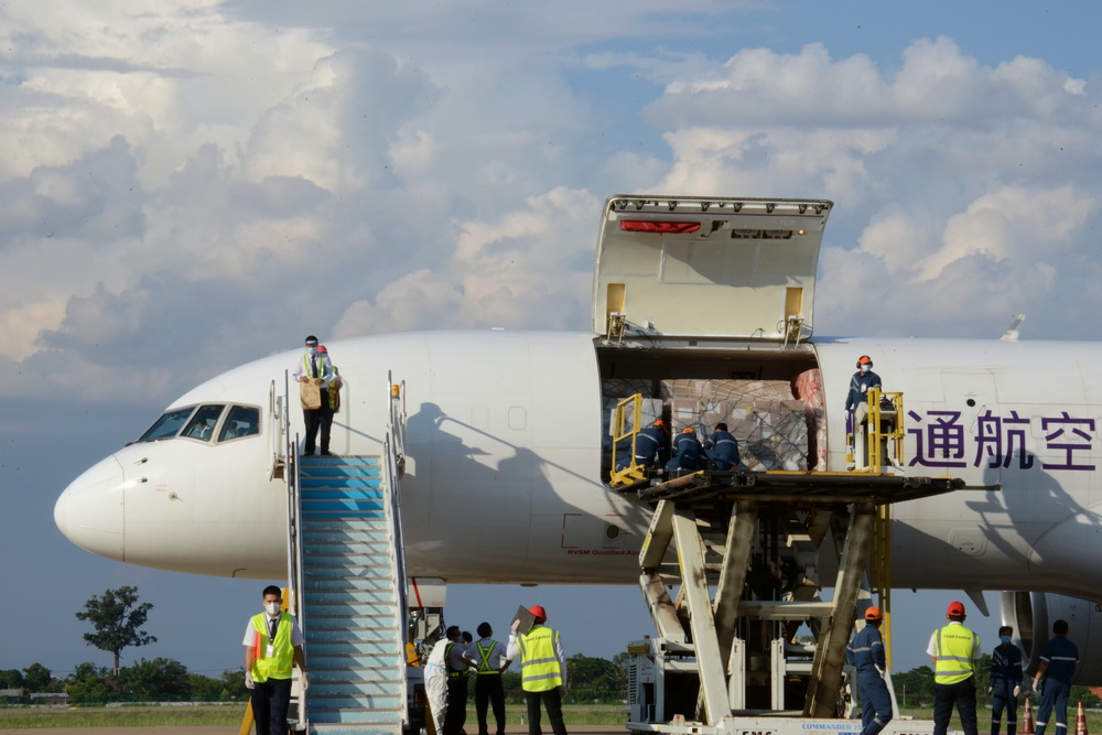 5月10日，在老挝万象瓦岱国际机场，老挝工作人员卸载并装运中方援助物资。