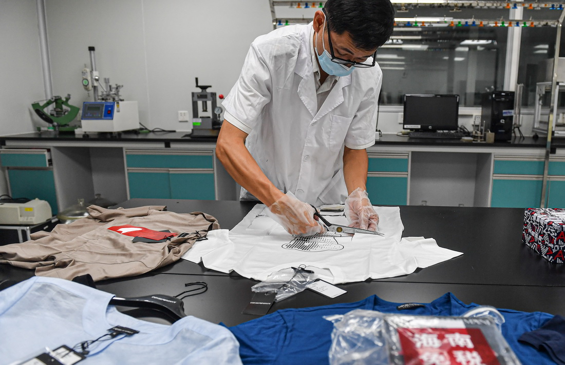 8月5日，海口海關技術中心工作人員王史在實驗室對離島免稅服飾進行取樣，為后續檢測做準備。