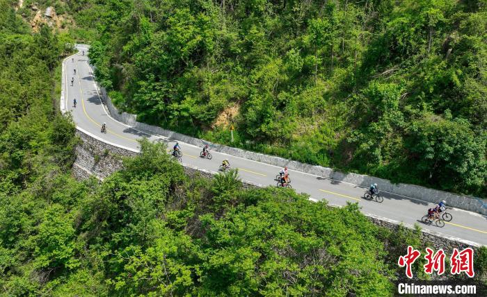 車手騎行在風景秀麗、蜿蜒曲折的鄉村公路上 楊東 攝